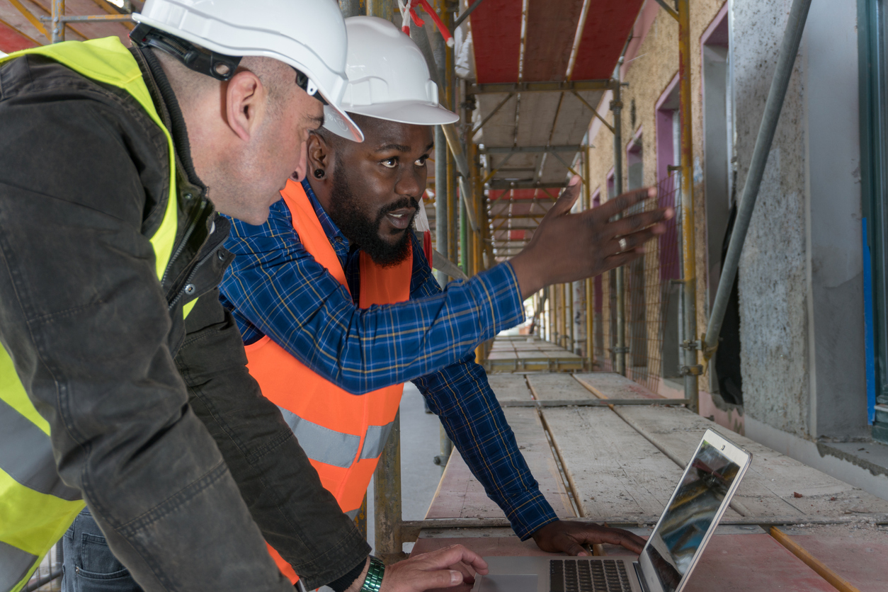 Two construction workers, an African american and a white Leading through organizational change with executive coaching