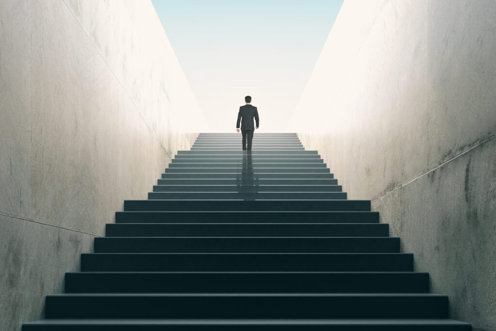 Business professional walking up stairs toward success and leadership growth
